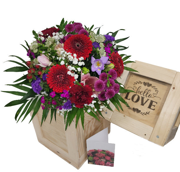 Blumenstrauß in Holzkiste mit Grußkarte und ein kleines Abenteuer
