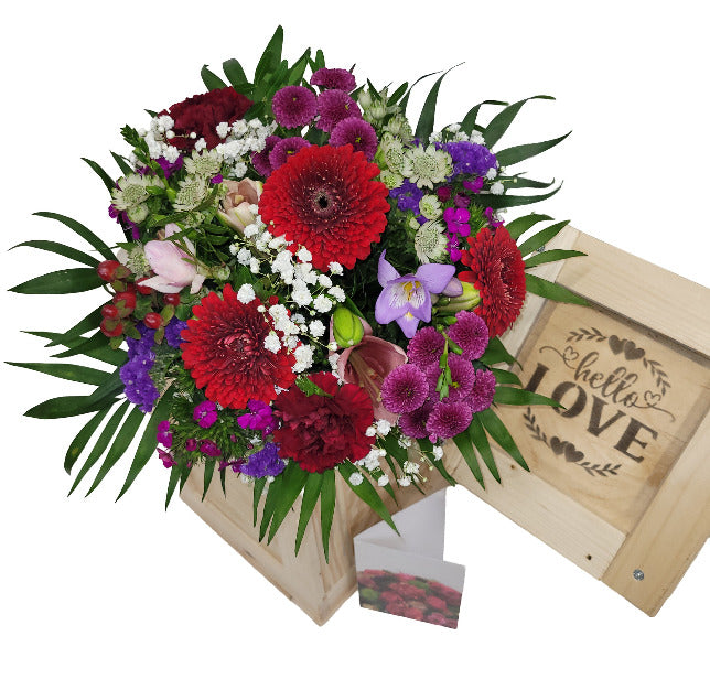 Blumenstrauß in Holzkiste mit Grußkarte und ein kleines Abenteuer